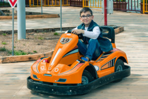 boy riding in orange go kart